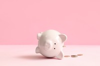 Sparschwein liegt auf der Seite, Münzen daneben